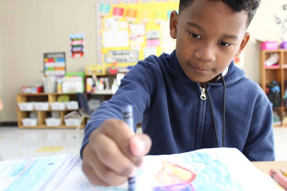 boy in classroom coloring
